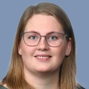 En smilende Marie Kornum Petersen med blå baggrund